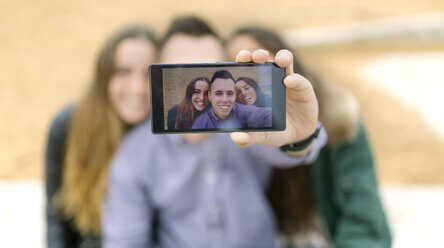 Selfie von lächelnden Freunden auf dem Display eines Smartphones - MGOF001138