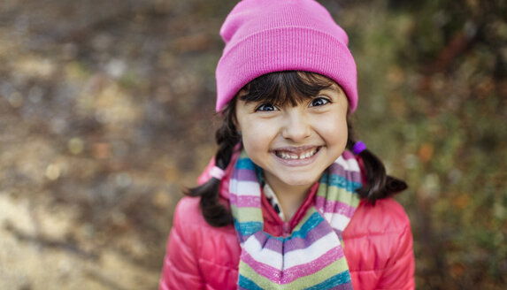 Portrait of grinning little girl wearing cap and scarf in autumn - MGOF001155