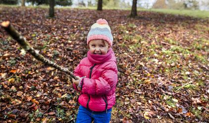 Portrait of happy little girl playing on a meadow in autumn - MGOF001160