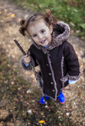Portrait of smiling little girl in autumn looking up to the camera - MGOF001162