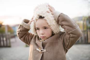 Girl wearing furry hood outdoors - RAEF000709