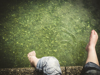 Girl's feet at the edge of a lake - GSF001044