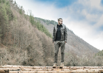 Bulgarien, Rhodopengebirge, junger Mann auf Baumstämmen stehend - DEGF000600