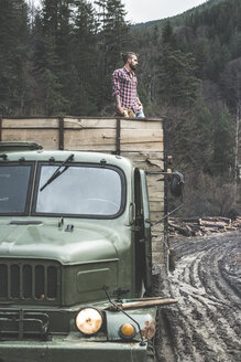 Bulgarien, Rhodopengebirge, junger Mann auf einem Lastwagen stehend - DEGF000601