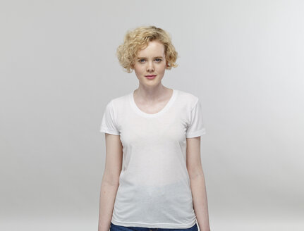 Porträt einer blonden Frau mit weißem T-Shirt vor einem grauen Hintergrund - RHF001085