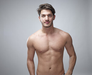 Portrait of shirtless young man in front of grey background - RHF001116