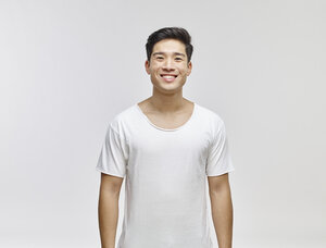 Porträt eines lächelnden jungen Mannes mit weißem T-Shirt - RHF001128