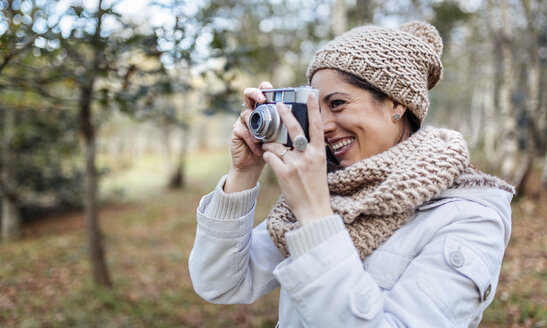 Glückliche Frau beim Fotografieren im Wald - MGOF001171