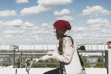 Young woman on bicycle holding cell phone - UUF006179