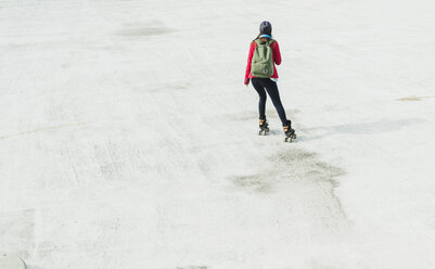 Junge Frau mit Rucksack beim Inline-Skaten auf dem Parkdeck - UUF006208