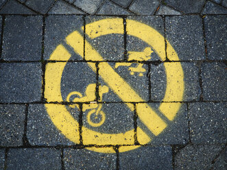 Yellow prohibition sign, riding bicycle and skateboarding on pavement - DISF002279