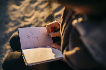 Junge Frau am Strand sitzend mit Notizbuch, Nahaufnahme - JRFF000229