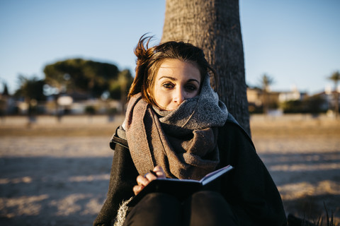 Spanien, Tarragona, Porträt einer jungen Frau in der Dämmerung im Winter, lizenzfreies Stockfoto