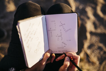 Junge Frau am Strand sitzend mit Notizbuch, Nahaufnahme - JRFF000233