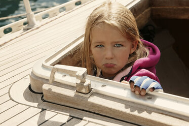 Mädchen schaut aus der Kajüte eines Segelboots und schmollt - TMF000081