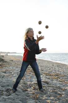 Spanien, Mallorca, Junge jongliert mit drei Bällen am Strand - TMF000085