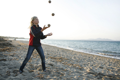 Spain, Majorca, boy juggling with three balls on the beach stock photo