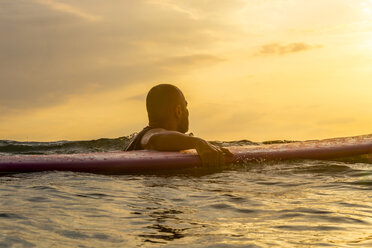 Surfer mit Surfbrett im Abendlicht - KNTF000214