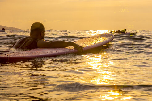 Surfer mit Surfbrett im Abendlicht - KNTF000215
