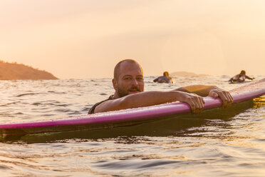 Surfer mit Surfbrett im Abendlicht - KNTF000216