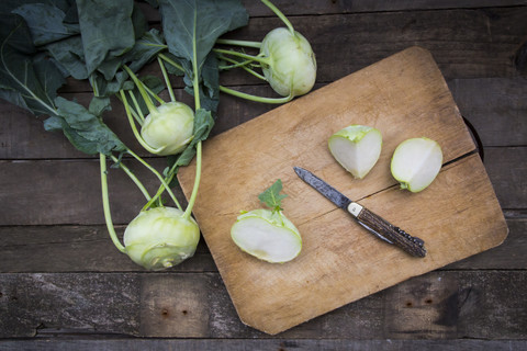 Bio-Kohlrabi auf Holz, Messer auf Schneidebrett, halbiert, lizenzfreies Stockfoto