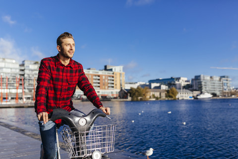 Ireland, Dublin, young man at city dock with city bike stock photo
