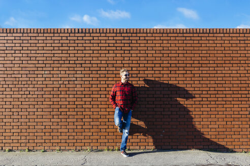 Young man leaning against brick wall - BOYF000061
