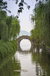 China, Zhejiang, Hangzhou, Historische Brücke über einen kleinen Kanal am westlichen Seeufer - NKF000419