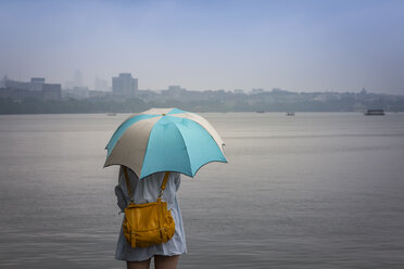 China, Zhejiang, Hangzhou, Frauen mit Regenschirm blicken über den Westsee - NK000421