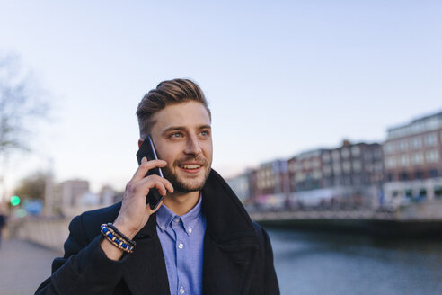 Irland, Dublin, Porträt eines jungen Geschäftsmannes, der mit einem Smartphone telefoniert - BOYF000078