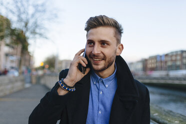 Irland, Dublin, Porträt eines jungen Geschäftsmannes, der mit einem Smartphone telefoniert - BOYF000082