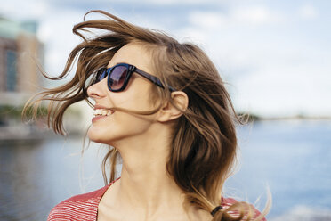 Porträt einer lächelnden Frau mit wehendem Haar und Sonnenbrille - BOYF000089