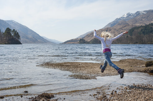 Großbritannien, Schottland, Schottische Highlands, Loch Shiel, Mädchen springt über Wasser - JBF000258