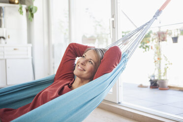 Smiling woman at home lying in hammock - RBF003567