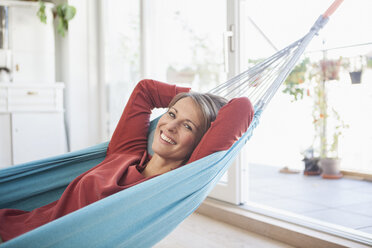 Smiling woman at home lying in hammock - RBF003568