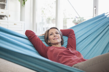 Smiling woman at home lying in hammock - RBF003570