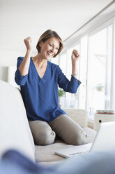 Happy woman at home shopping online - RBF003590