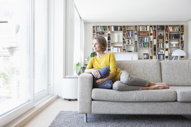 Entspannte Frau zu Hause auf der Couch - RBF003632