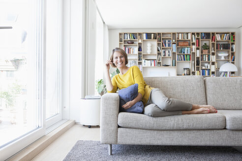 Entspannte Frau zu Hause auf der Couch - RBF003633