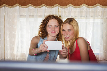 Zwei Freundinnen machen ein Selfie in einem Wohnwagen - HAPF000027