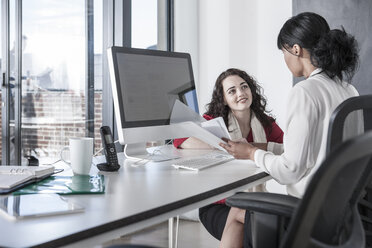 Zwei junge Frauen arbeiten zusammen im Büro - ZEF007486