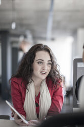 Young woman in office discussing with colleague - ZEF007511