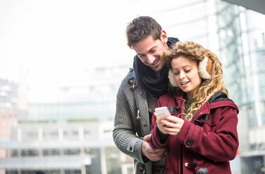 Italien, Mailand, Porträt eines Paares mit Blick auf ein Smartphone - OIPF000006