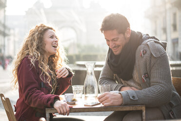 Italy, Milan, laughing couple sitting at sidewalk cafe having fun - OIPF000009