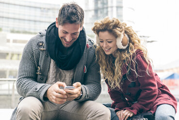 Italien, Mailand, Paar sitzt nebeneinander und benutzt Smartphone - OIPF000015