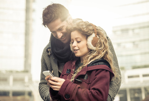 Couple looking together at smartphone stock photo