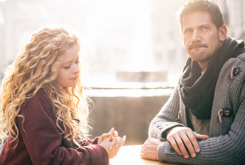 Displeased couple sitting together at a table stock photo