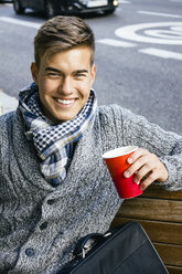 Portrait of smiling teenage boy with coffee to go - ABZF000171