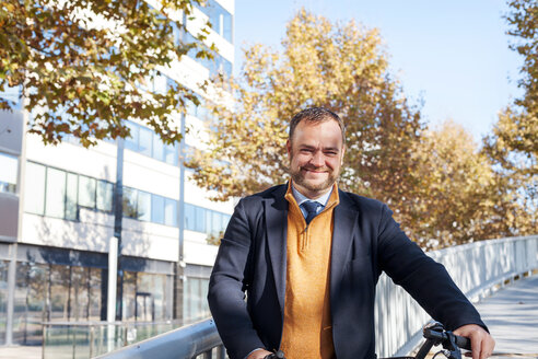Spanien, Barcelona, Porträt eines lächelnden Geschäftsmannes mit Fahrrad - VABF000002