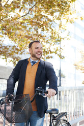 Spain, Barcelona, portrait of happy businessman with bicycle - VABF000003